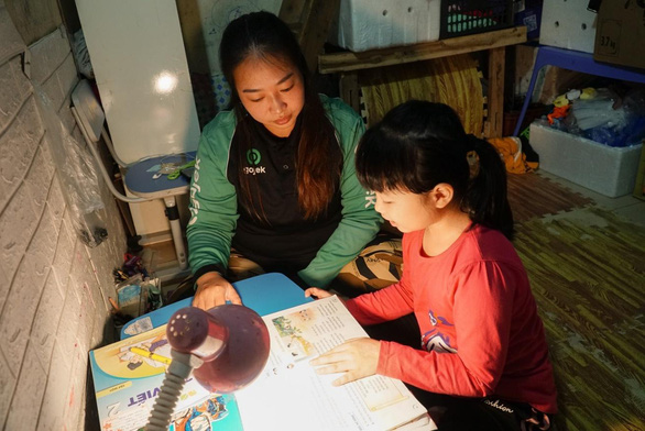 Whenever Nguyen Huyen Ly and her husband are not on the road, they spend time helping their oldest child with schoolwork. Photo: Nguyen Hien / Tuoi Tre