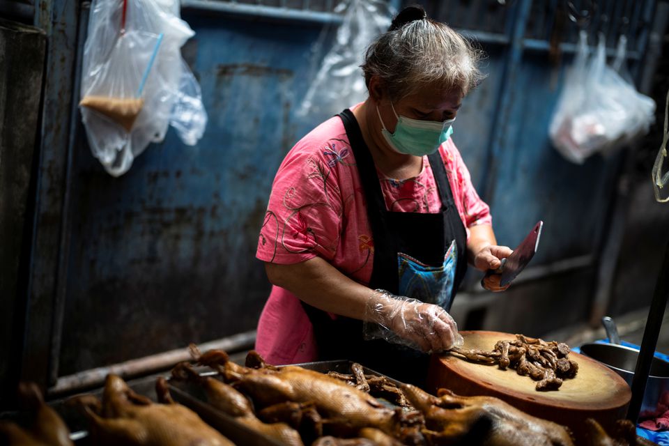 Janya Saetang, 55, a sister of Ladda Saetang who died at age 66 of the coronavirus disease (COVID-19) in May, during Thailand's worst wave of infections, chops meat at her late sister's food stall in Bangkok's Chinatown, Thailand, October 4, 2021. Photo: Reuters