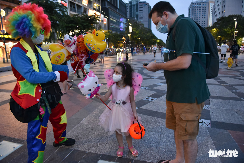 A foreign kid goes for a walk in a Halloween costume with her father on Nguyen Hue Pedestrian Street in District 1, Ho Chi Minh City, October 31, 2021. Photo: Ngoc Phuong / Tuoi Tre