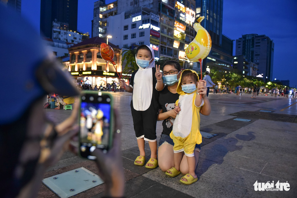 Huynh Thao and her children pose for a photo in Halloween costumes on Nguyen Hue Pedestrian Street in District 1, Ho Chi Minh City, October 31, 2021. Photo: Ngoc Phuong / Tuoi Tre