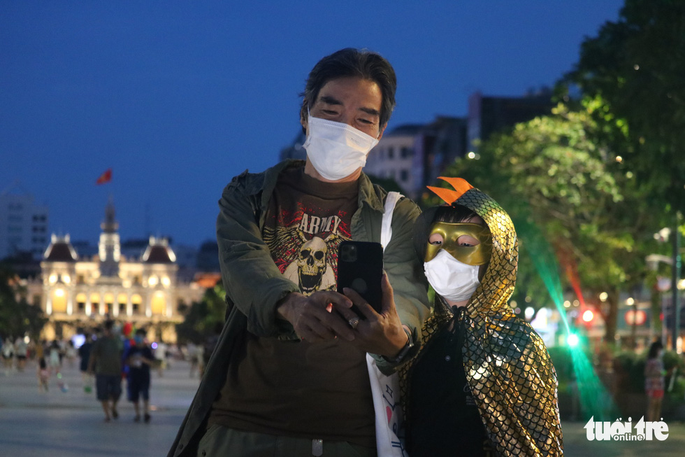 Anh Duc goes for a walk in a Halloween outfit with his grandfather on Nguyen Hue Promenade in District 1, Ho Chi Minh City, October 31, 2021. Photo: Ngoc Phuong / Tuoi Tre