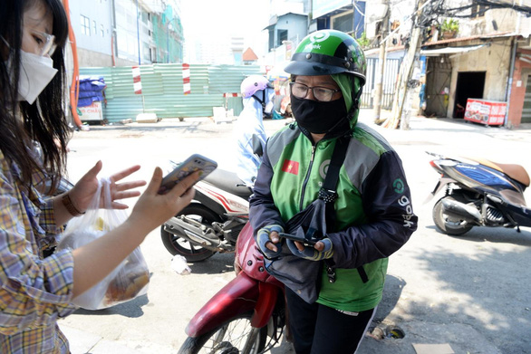 Nguyen Thi Nguyet Hong delivers food to the customer. Photo: T.T.D / Tuoi Tre