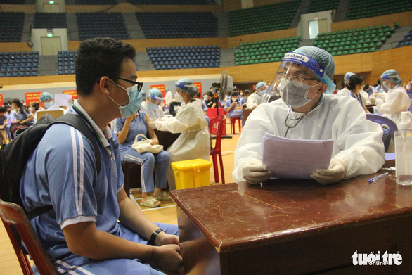 A doctor talks with a student during a COVID-19 vaccination session in Da Nang City, Vietnam, November 2, 2021. Photo: Truong Trung / Tuoi Tre