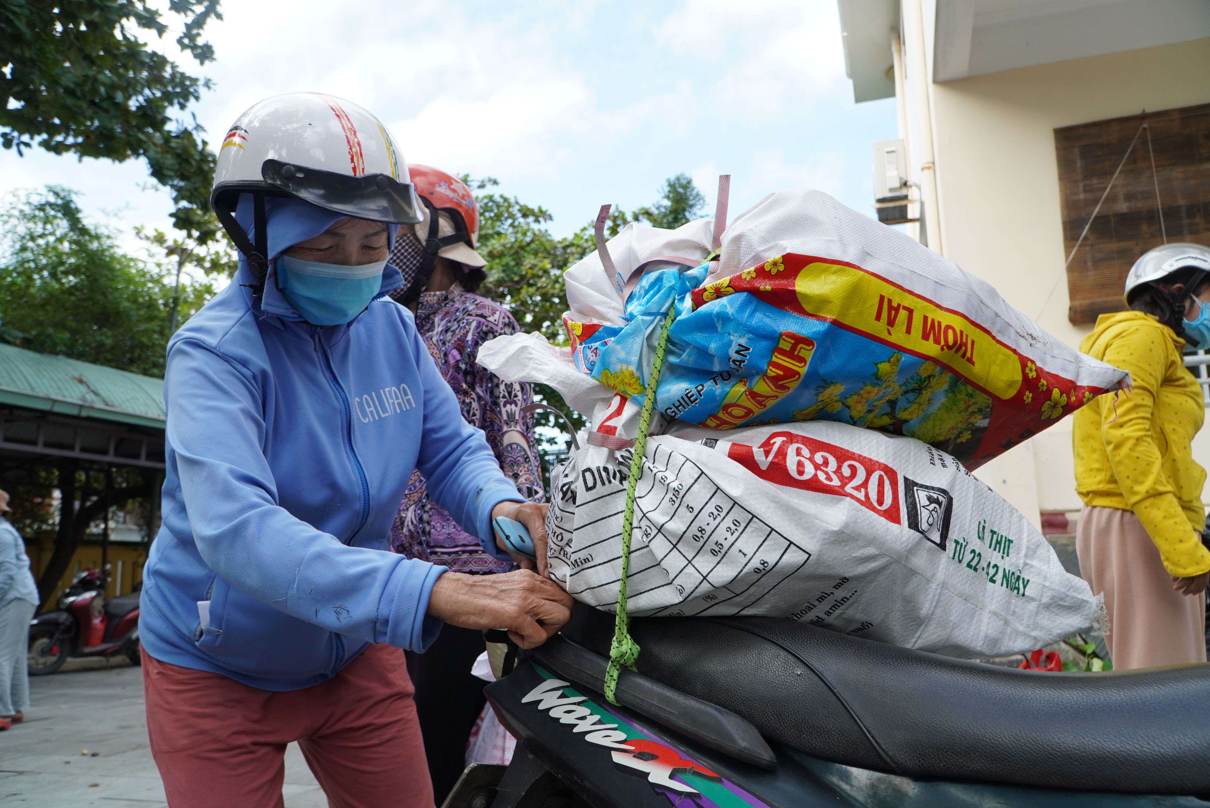 A woman with bags of recyclables stacked on her motorbike at the trash-for-rice event. Photo: Le Trung / Tuoi Tre