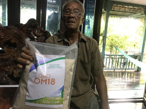 Huynh Van The with a pack of organic rice grown from his hybrid fish-rice farming model. Photo: T.Nhon / Tuoi Tre