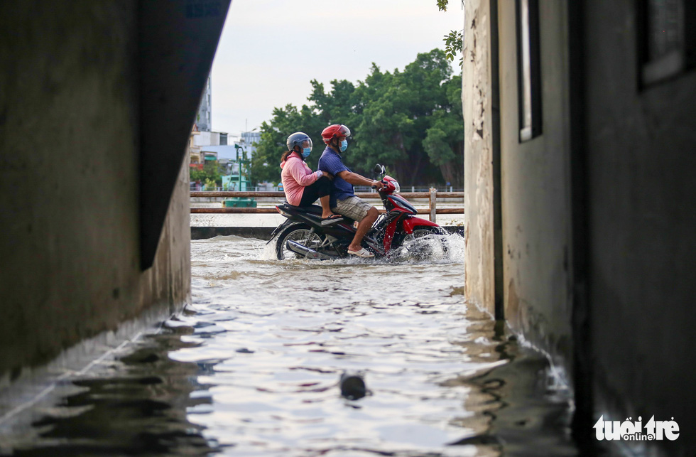 A couple ride a motorbike on a flooded street in Ho Chi Minh City, November 5, 2021. Photo: Chau Tuan / Tuoi Tre