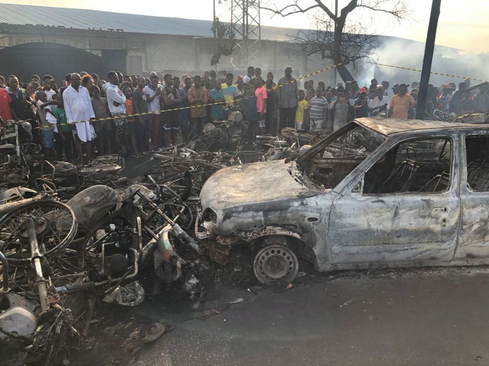 People watch burnt car and motorcycles after a fuel tanker explosion in Freetown, Sierra Leone November 6, 2021. Photo: National Disaster Management Agency-Sierra Leone/Handout via Reuters
