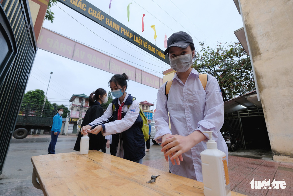 Students use hand sanitizer before entering Tay Dang Middle School in Ba Vi District, Hanoi, November 9, 2021. Photo: Nam Tran / Tuoi Tre