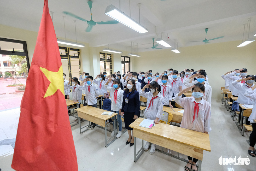 Students and their teacher attend a flag raising ceremony at Tay Dang Middle School in Ba Vi District, Hanoi, November 9, 2021. Photo: Nam Tran / Tuoi Tre