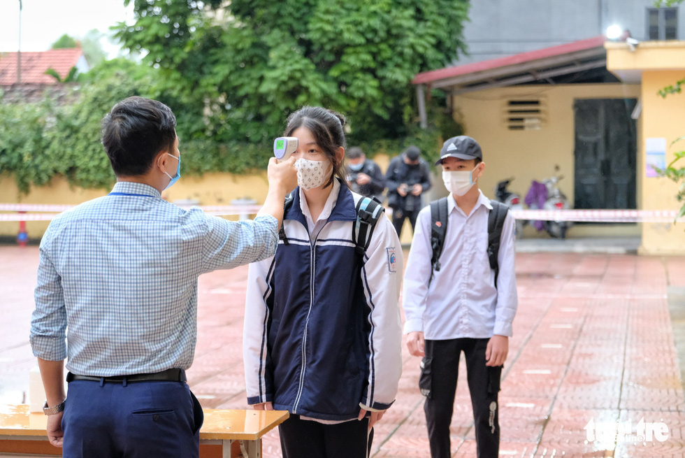 A student has her body temperature measured at Tay Dang Middle School in Ba Vi District, Hanoi, November 9, 2021. Photo: Nam Tran / Tuoi Tre