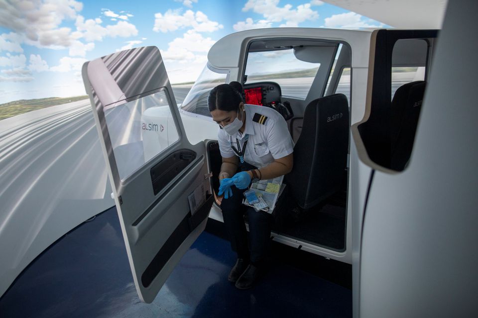 Cadet Casey Abadilla, wearing a mask and gloves as part of coronavirus disease (COVID-19) protocols, steps out of a flight simulator at the Alpha Aviation Group campus in Clark, Pampanga province, Philippines, November 3, 2021. Photo: Reuters