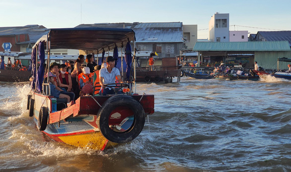 Tourists sit on a boat to visit Cai Rang Floating Market in Can Tho City, Vietnam. Photo: Chi Quoc / Tuoi Tre
