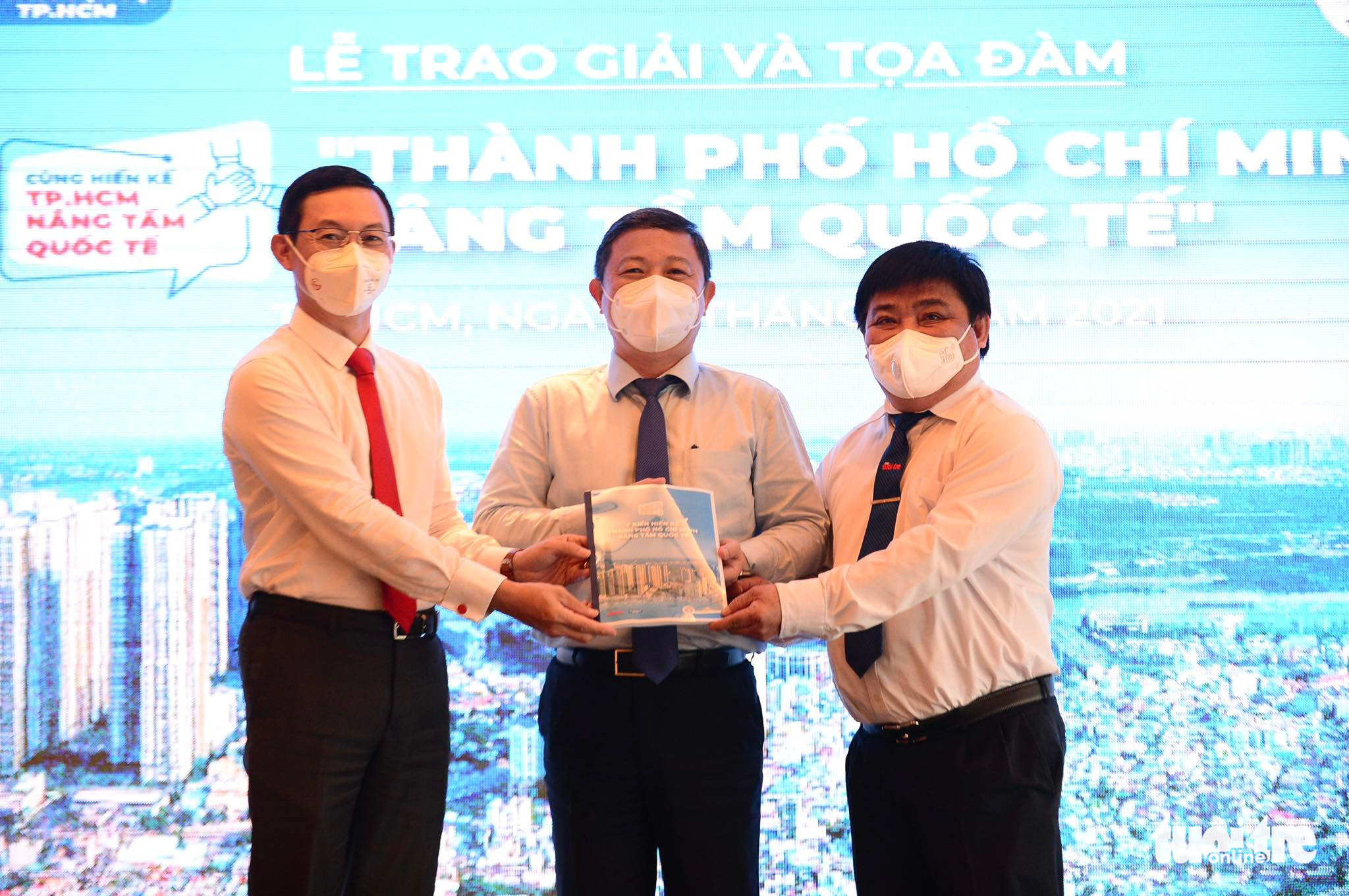 Vice-chairman of the Ho Chi Minh City People’s Committee Duong Anh Duc (C) receives the compilation of winning entries of the ‘Ho Chi Minh City Goes Global’ contest from Tuoi Tre Editor-in-Chief Le The Chu (R) and director of the Department of Foreign Affairs Tran Phuoc Anh (L). Photo: Quang Dinh / Tuoi Tre