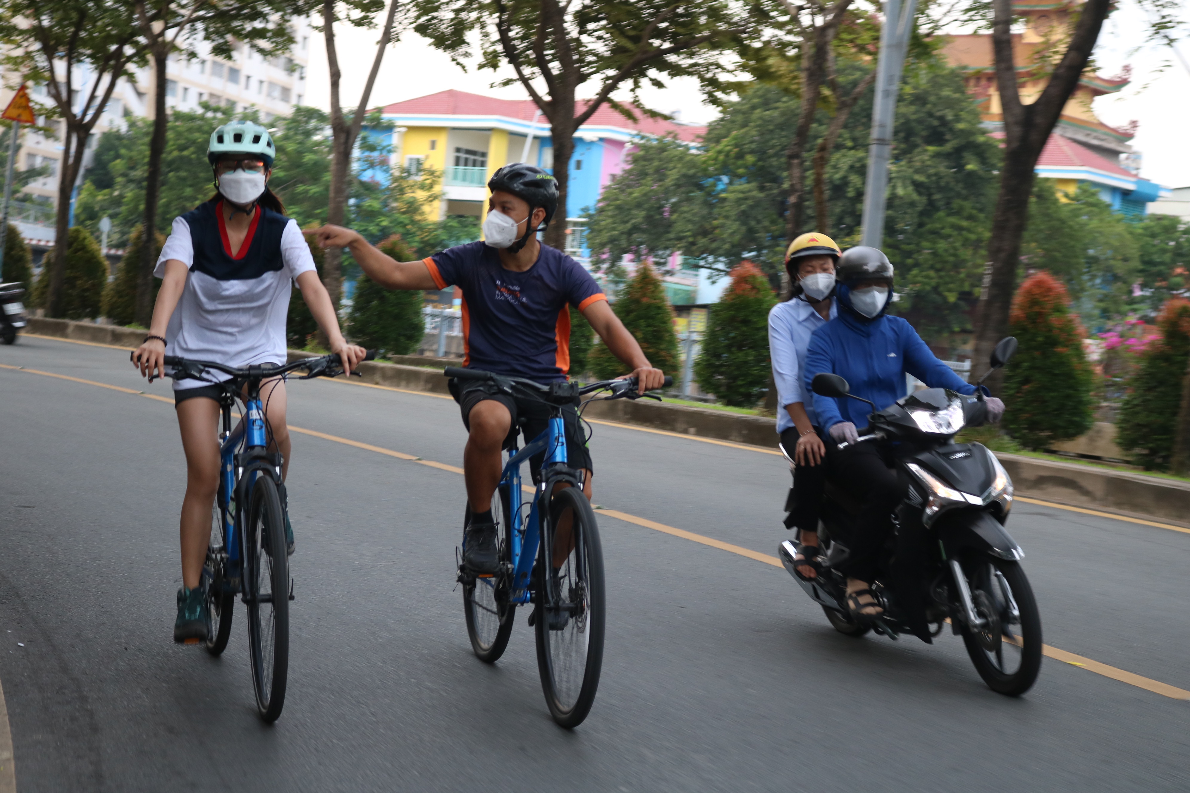 Minh Thuy (right) and Vo Hoang, two regular customers at Cao Cao Adventures, cycle along Truong Sa Street in District 1 in Ho Chi Minh City on November 3, 2021. Photo: Hoang An / Tuoi Tre News