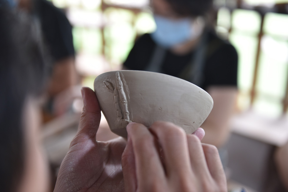A customer decorates a clay bowl at the Nhan Tri Dung pottery workshop in District 7, Ho Chi Minh City. Photo: Ngoc Phuong – Hoang An / Tuoi Tre.