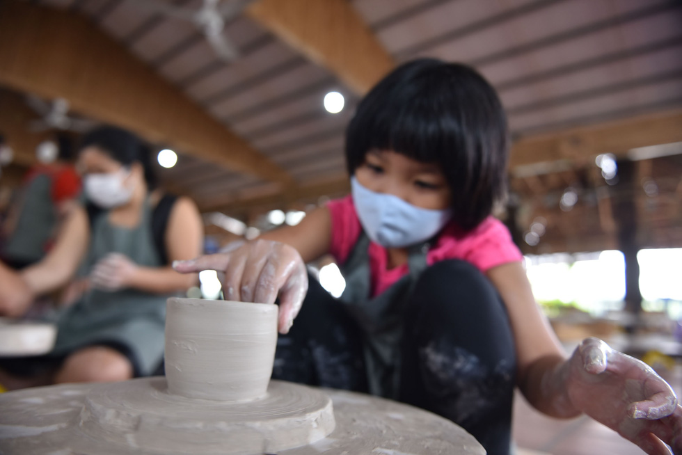 A 6-year-old girl makes a clay mug at the Nhan Tri Dung pottery workshop in District 7, Ho Chi Minh City. Photo: Ngoc Phuong – Hoang An / Tuoi Tre.