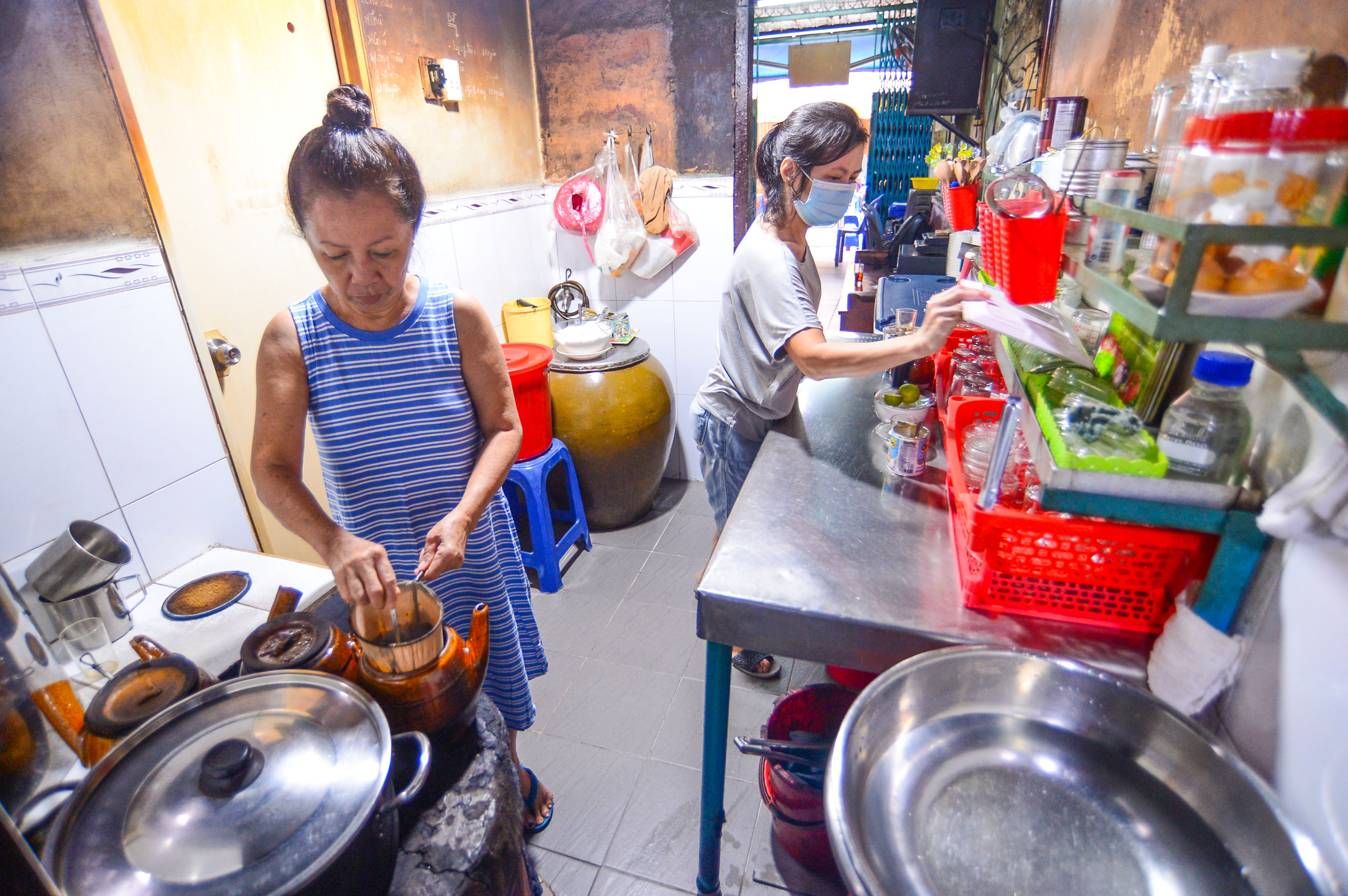 Nguyen Thi Suong (left) and her younger sister make drinks in the kitchen of Cheo Leo Cafe in District 3 in Ho Chi Minh City. Photo: Quang Dinh / Tuoi Tre