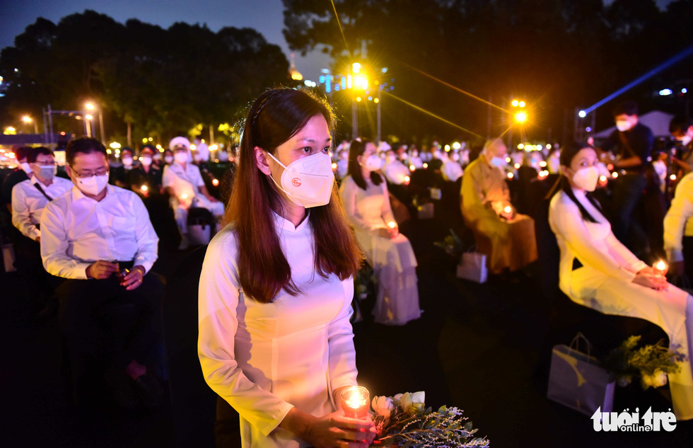 Participants hold lit candles in their hands at the mourning ceremony for COVID-19 victims at the Thong Nhat Hall in Ho Chi Minh City on the evening of November 19, 2021. Photo: Duyen Phan / Tuoi Tre