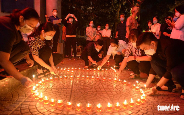 This image shows people conducting a memorial service for COVID-19 victims in an alley in District 4, Ho Chi Minh City on November 19, 2021. Photo: Tu Trung / Tuoi Tre