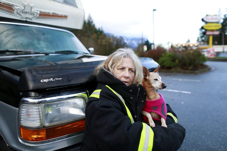 Delia McLaren holds her dog Diamond in the parking lot of a Tim Hortons where she has been stranded for days after rainstorms caused flooding and landslides near Hope, British Columbia, Canada November 19, 2021. Photo: Reuters
