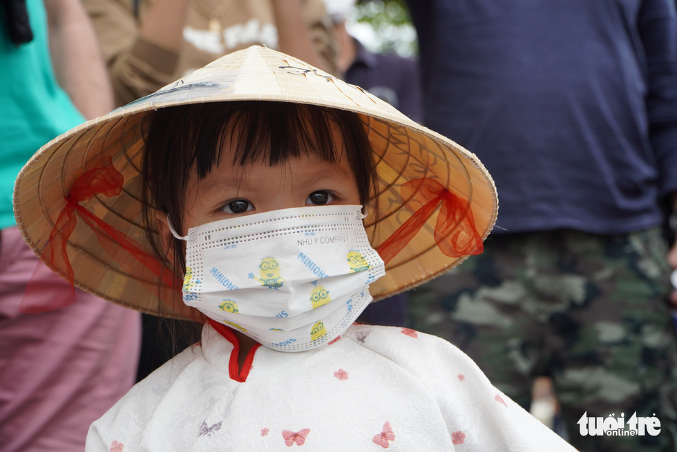 A young tourist wears non la at Hoi An City in Vietnam’s central Quang Nam Province, November 20, 2021. Photo: Le Trung / Tuoi Tre