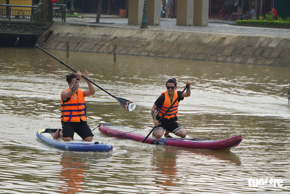 Tourists travel the Thu Bon River in Hoi An City, Quang Nam Province, Vietnam on paddleboards, November 20, 2021. Photo: Le Trung / Tuoi Tre
