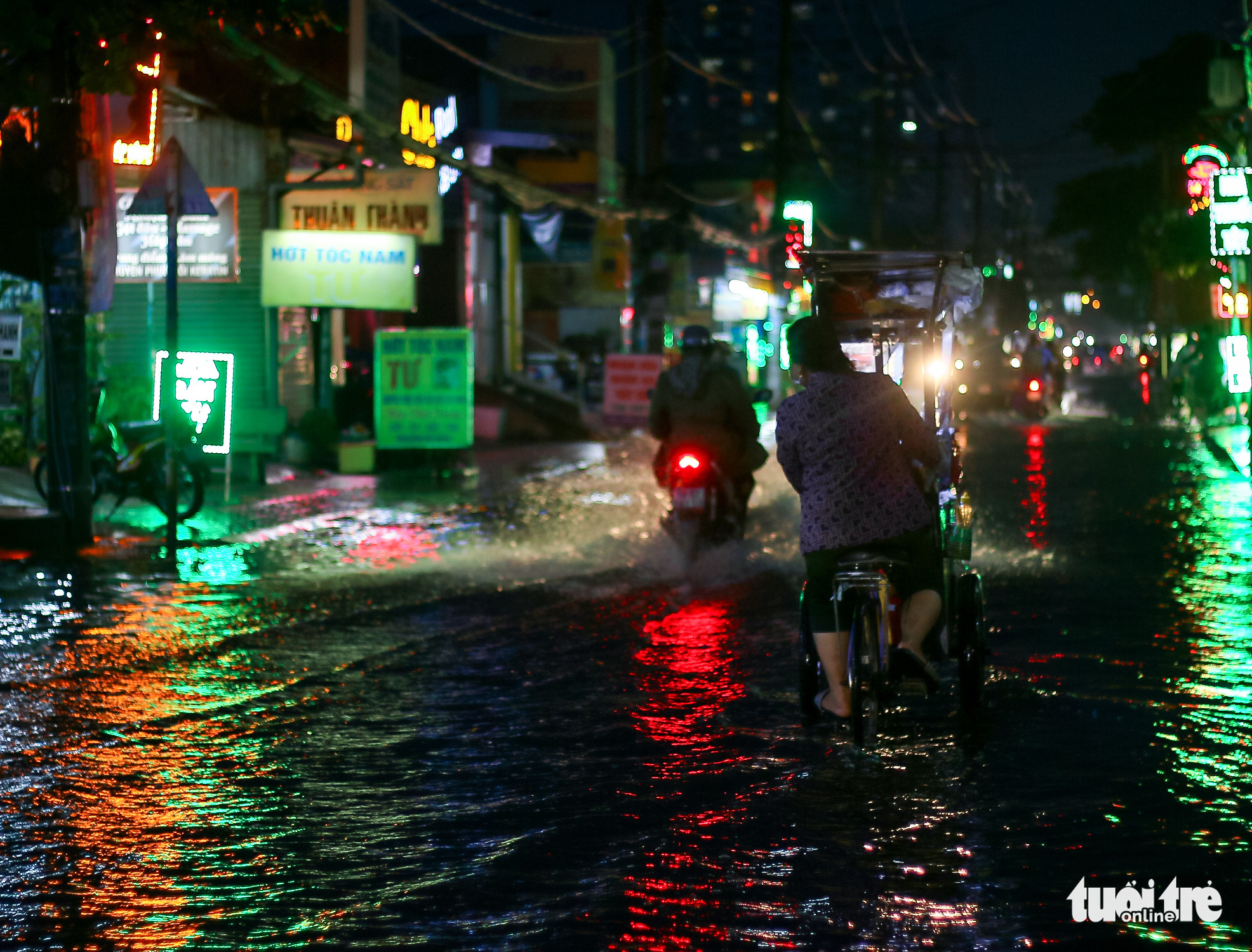 Commuters travel on a flooded street in Nha Be District, Ho Chi Minh City, November 20, 2021. Photo: Chau Tuan / Tuoi Tre