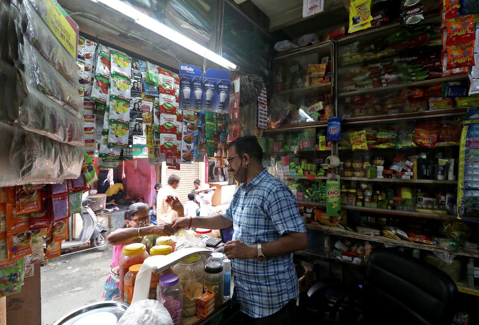 Shivkumar Singh, an owner of a store selling consumer goods, attends to a customer at his store in Dharavi, Mumbai, in the western state of Maharashtra, India, November 18, 2021. Photo: Reuters