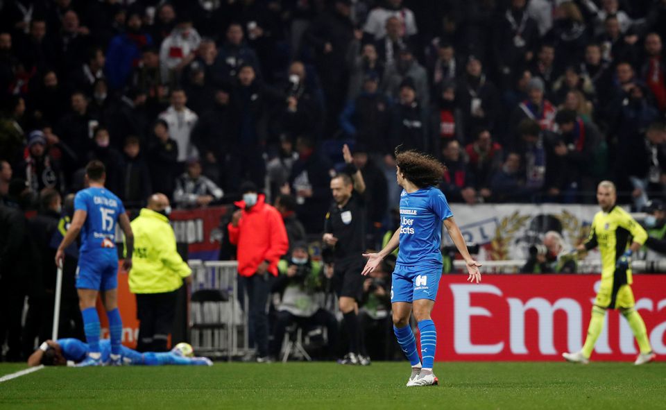 Soccer Football - Ligue 1 - Olympique Lyonnais v Olympique de Marseille - Groupama Stadium, Lyon, France - November 21, 2021. Olympique de Marseille's Matteo Guendouzi reacts after Dimitri Payet goes down after being hit by a water bottle thrown by a fan leading to the game being interrupted. Photo: Reuters