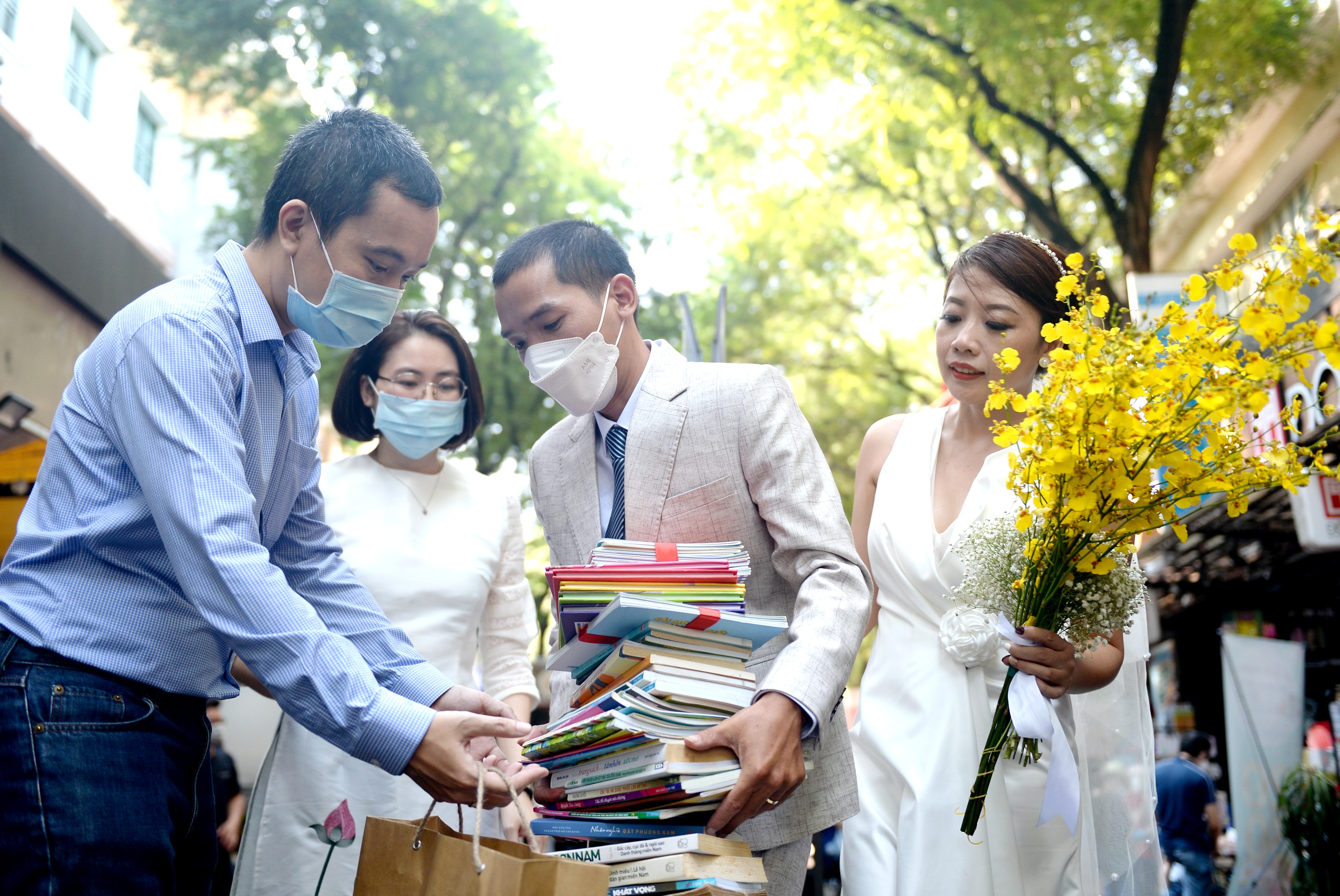 Tu Anh carries the books gifted by his friends at the wedding party in Ho Chi Minh City, November 21, 2021. Photo: Tu Trung / Tuoi Tre