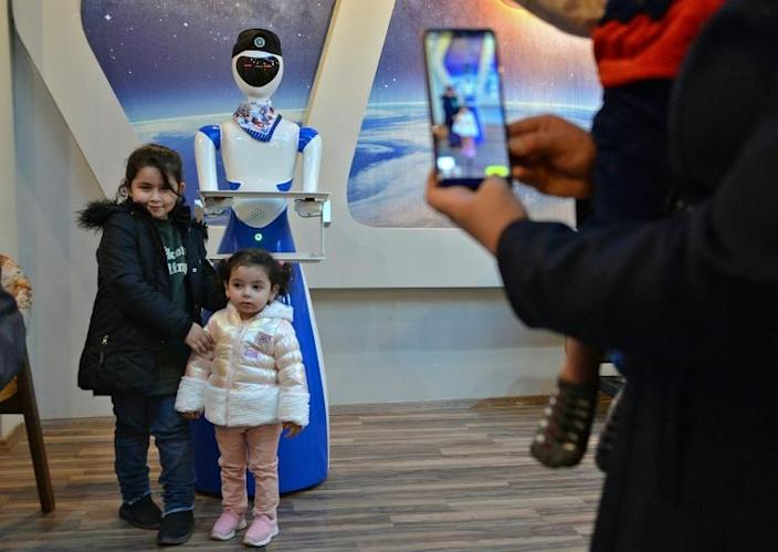 Children pose for a picture next to a robot waiter at the 'White Fox' restaurant in the eastern part (left bank of the Tigris river) of Iraq's northern city of Mosul on November 17, 2021. Photo: AFP