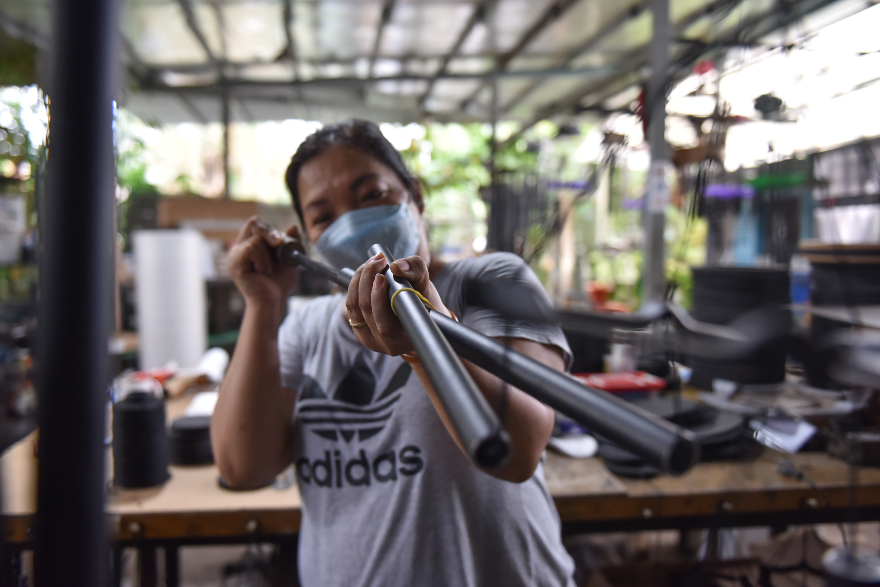 A staff cleans the tubes before putting them into a set of wind chimes. Photo: Ngoc Phuong / Tuoi Tre News