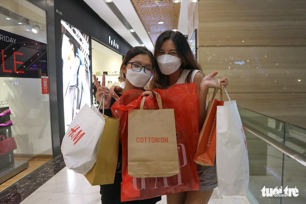 Tran Tu Uyen, a resident of Tan Phu District, and her friend pose with shopping bags at Vincom Center in District 1, Ho Chi Minh City on November 26, 2021. Photo: Ngoc Phuong / Tuoi Tre