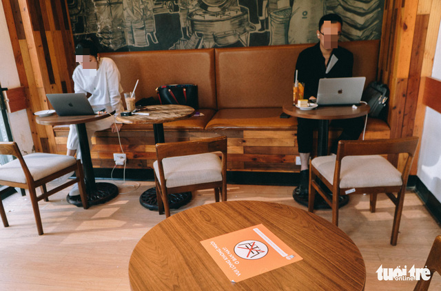 A table is left empty to ensure a safe distance between customers at a coffee shop in Hanoi. Photo: Pham Tuan / Tuoi Tre