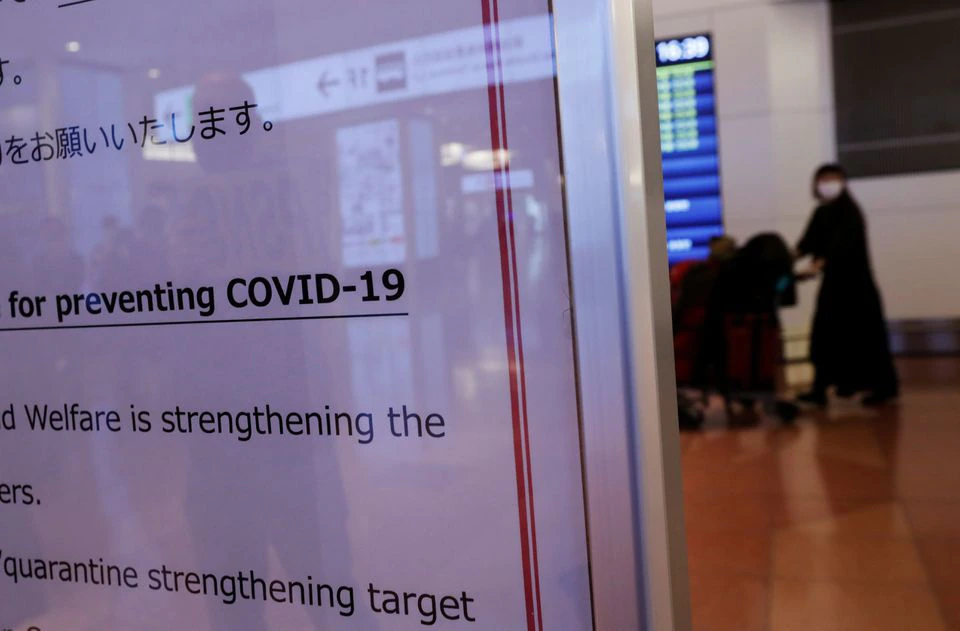 A passenger is seen behind a notice about the coronavirus disease (COVID-19) measurements at an arrival hall of Haneda airport's international terminal, amid the coronavirus disease (COVID-19) outbreak, in Tokyo, Japan, November 29, 2021. Photo: Reuters