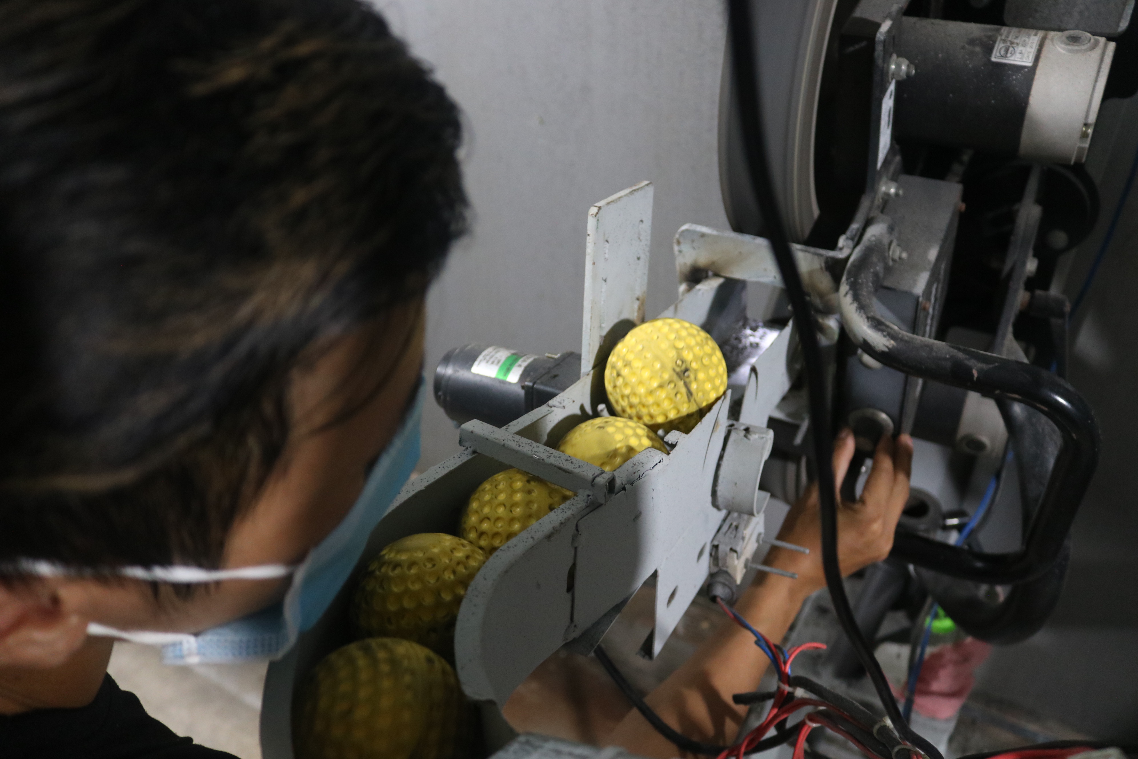 Le Long, a technician, checks an automatic ball line at Baseball Cage in Ho Chi Minh City’s District 7 on November 17, 2021. The ball lines were designed by Tung and manufactured in Vietnam while the pitching machines were imported for around VND250 million (US$ 11,005) each. Photo: Hoang An / Tuoi Tre News
