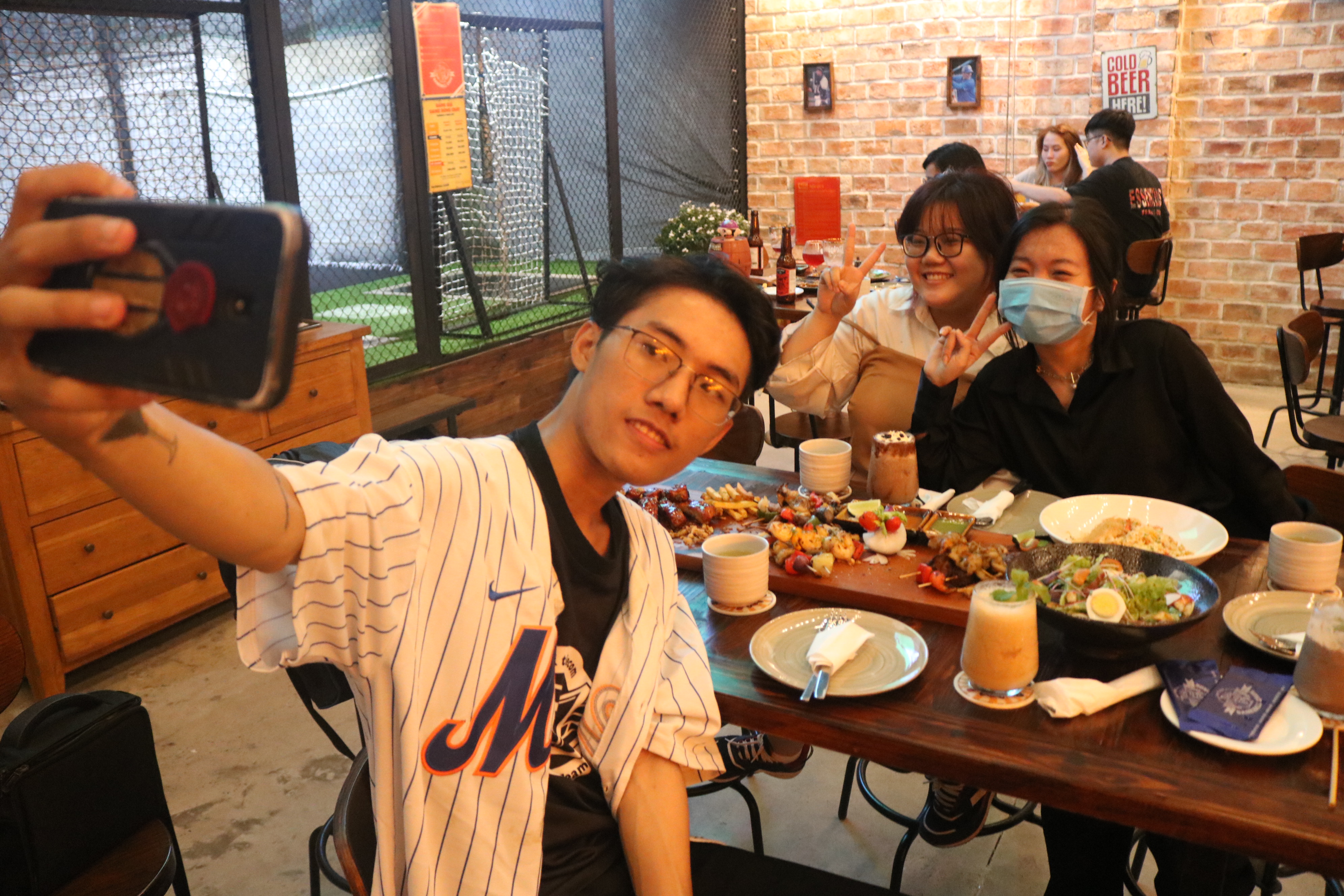 A group of young people takes a photo while having dinner at Baseball Cage in Ho Chi Minh City’s District 7 on November 17, 2021. Photo: Hoang An / Tuoi Tre News