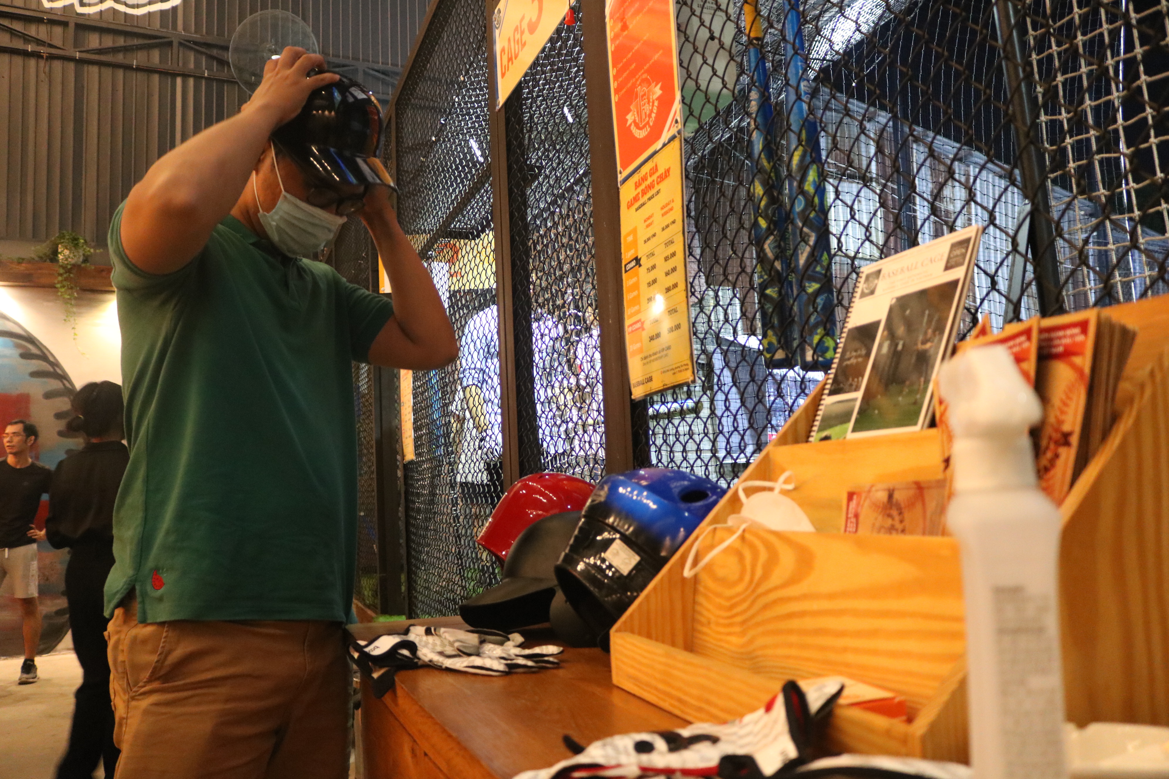 A player puts a helmet on before entering the batting cages at Baseball Cage in Ho Chi Minh City’s District 7 on November 17, 2021. Photo: Hoang An / Tuoi Tre News