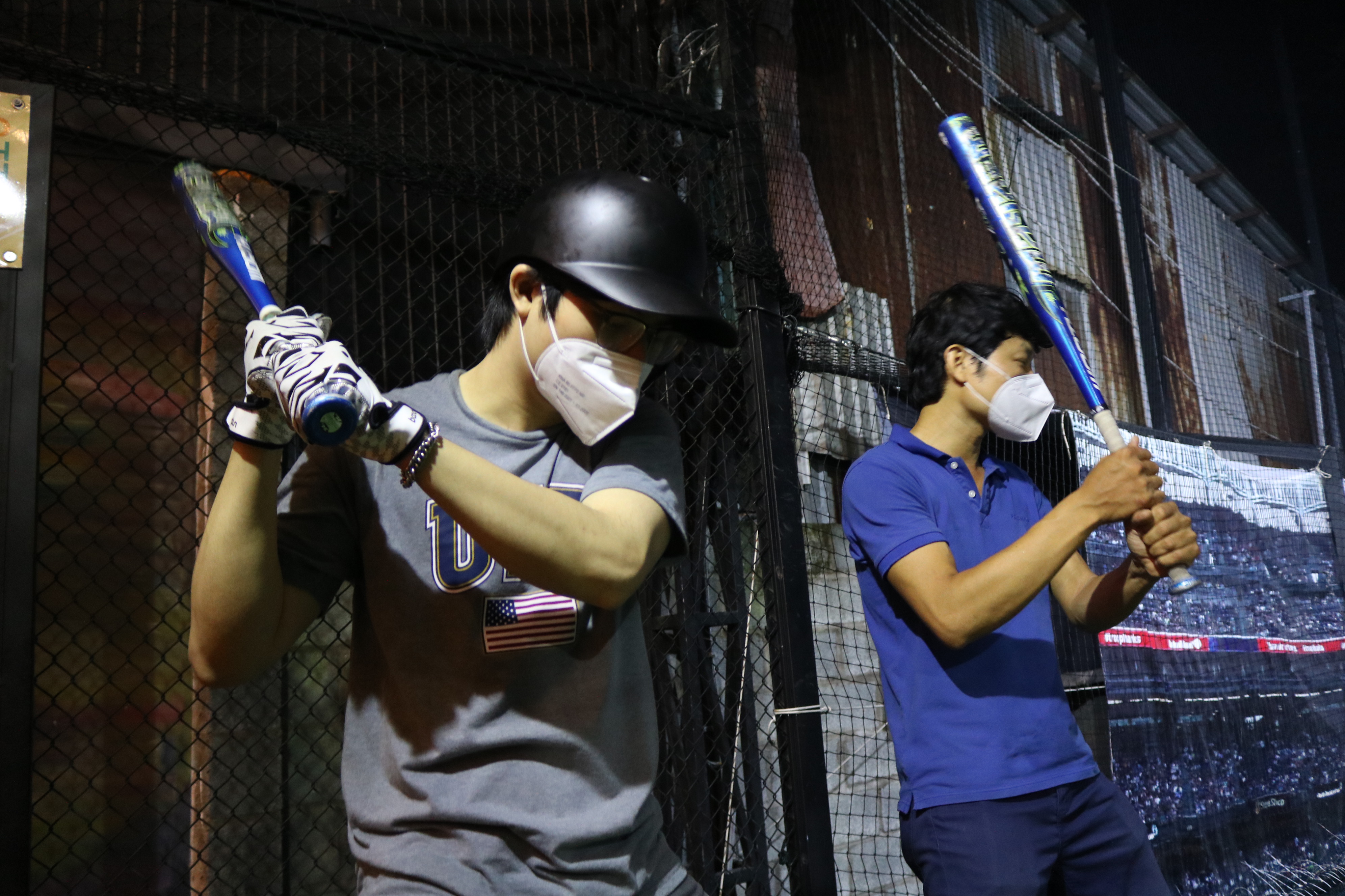 Le Van Tung (right), owner of Baseball Cage, instructs a batter on proper batting posture at Baseball Cage in Ho Chi Minh City’s District 7 on November 17, 2021. Photo: Hoang An / Tuoi Tre News