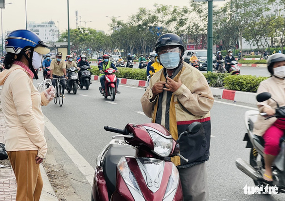 A commuter stops his motorbike to put on an extra coat in Ho Chi Minh City, December 4, 2021. Photo: Le Phan / Tuoi Tre