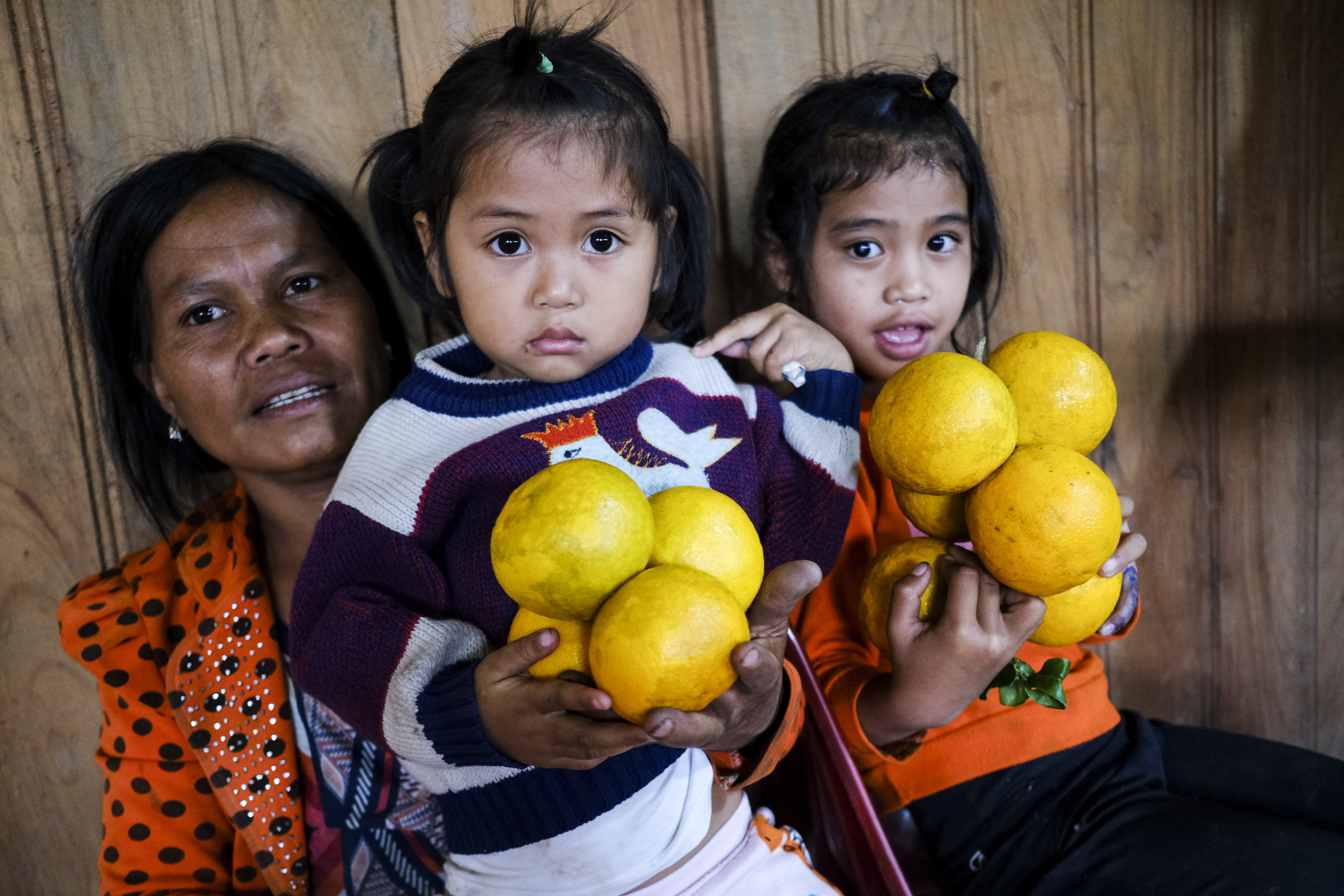 Local children pose for a photo with mountain oranges in Gary Commune, Quang Nam Province. Photo: Tuoi Tre