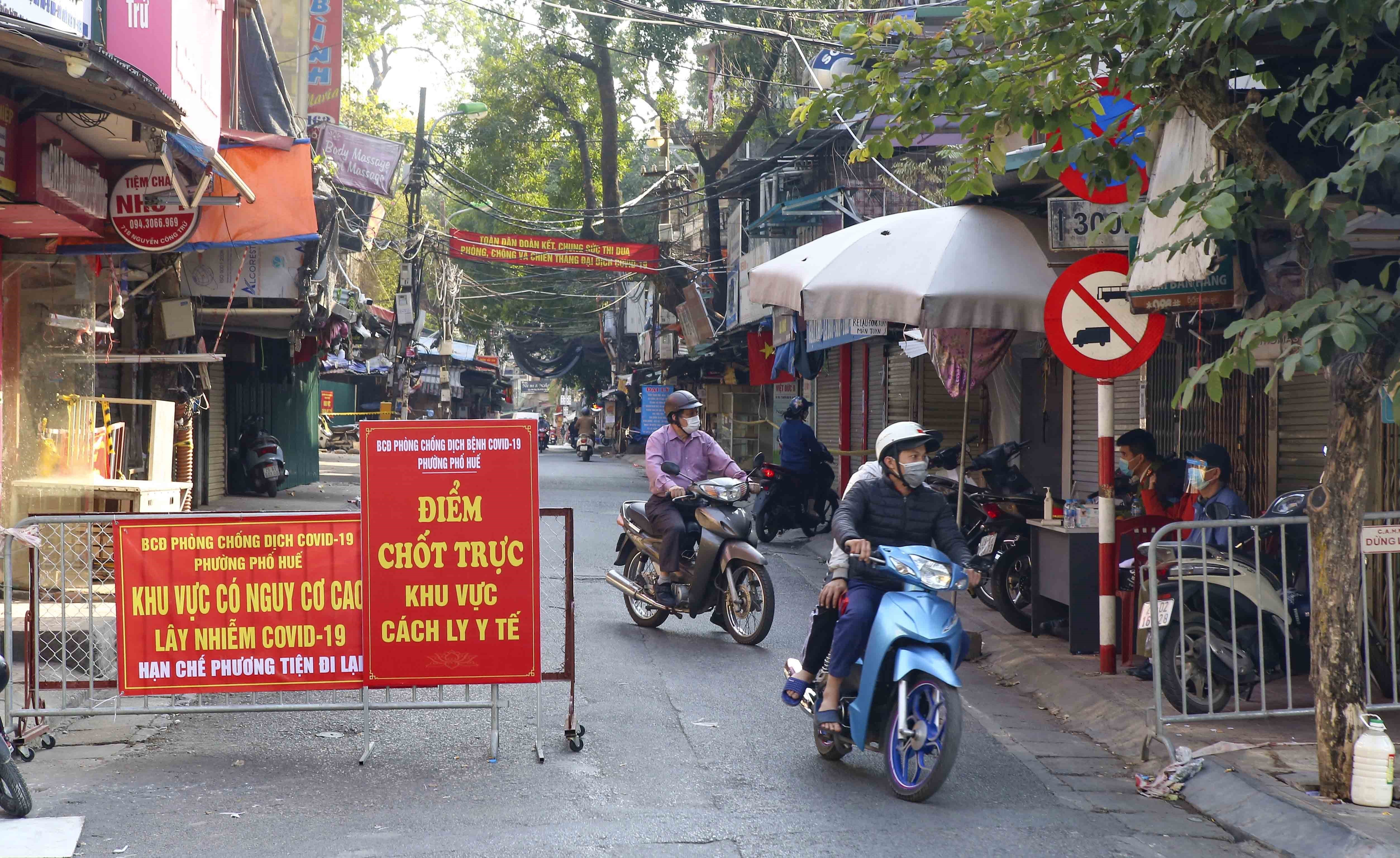 Commuters pass a COVID-19 checkpoint near Nguyen Cong Tru Market in Pho Hue Ward, Hai Ba Trung District, Hanoi, December 5, 2021. Photo: Vietnam News Agency