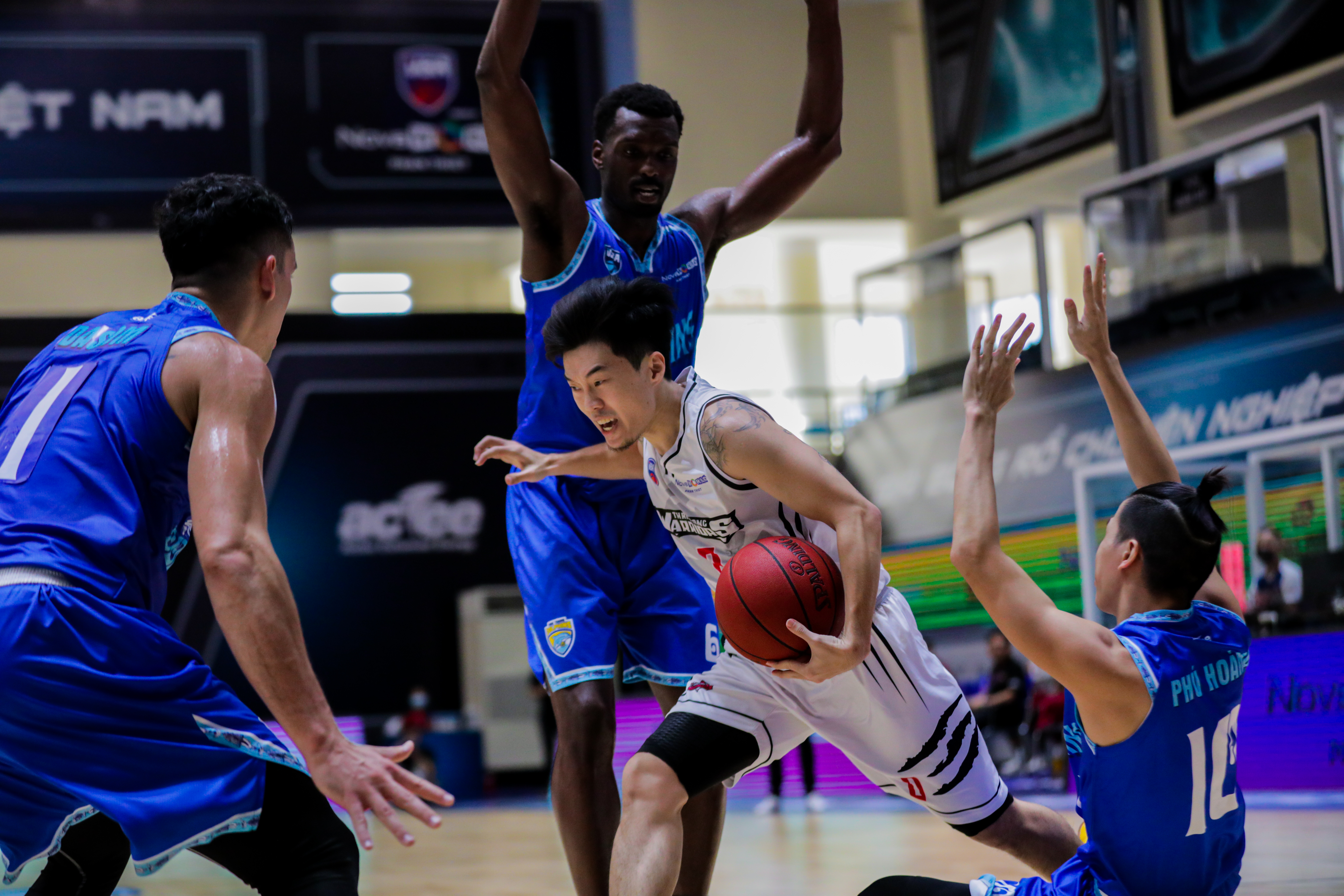 The Thang Long Warriors’ Hong Gia Lan (white jersey) dribbles past opponents in a 2021 VBA game. Photo: VBA