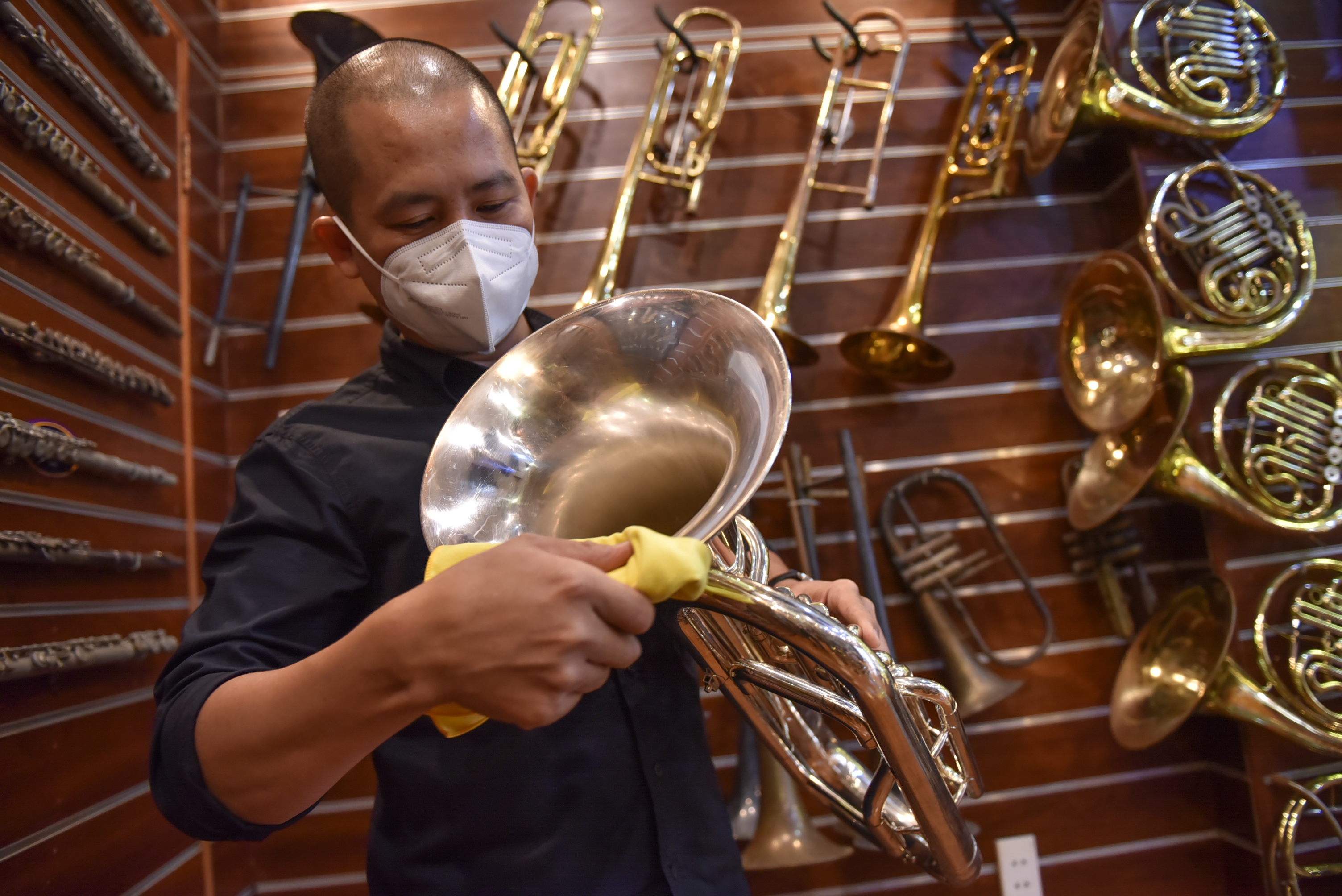 Nguyen Duy Khang cleans an instrument before handing it over to a customer at his repair shop in Tan Phu District in Ho Chi Minh City on December 6, 2021. Photo: Ngoc Phuong / Tuoi Tre News