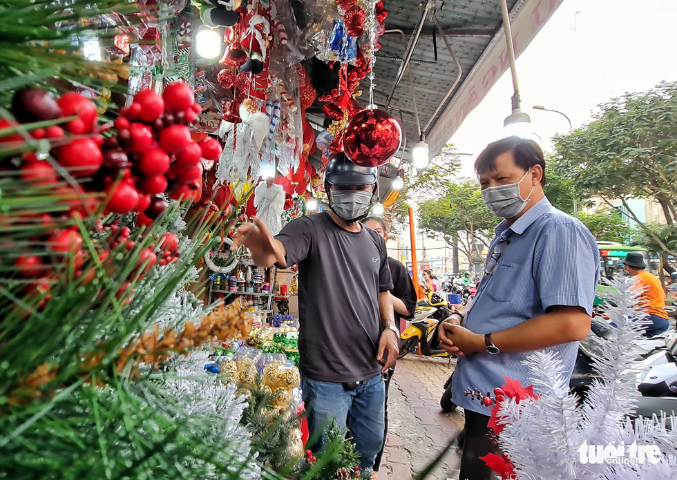 A customer chooses Christmas ornaments at a shop on Hai Thuong Lan Ong Street in District 5, Ho Chi Minh City. Photo: Cong Trieu / Tuoi Tre