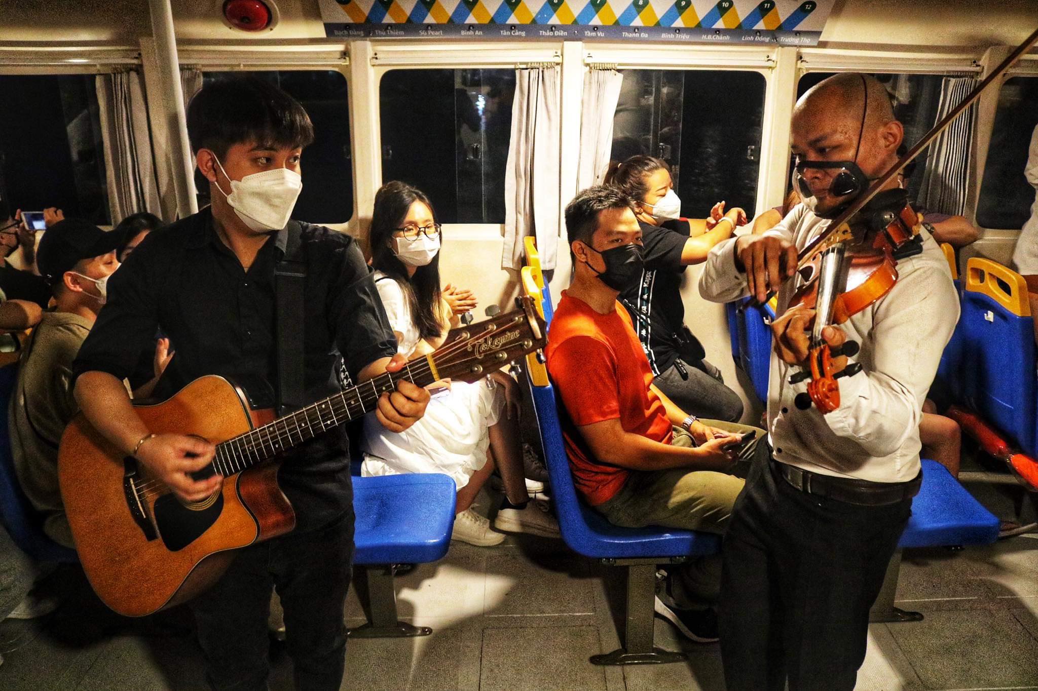 Passengers listen to a music performance on a night water bus on the Saigon River in Ho Chi Minh City, December 10, 2021. Photo: Hoang An / Tuoi Tre