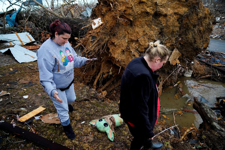 Amy Meno and Brooklyn Rogers search for belongings after a devastating outbreak of tornadoes ripped through several U.S. states in Earlington, Kentucky, U.S. December 11, 2021. Photo: Reuters