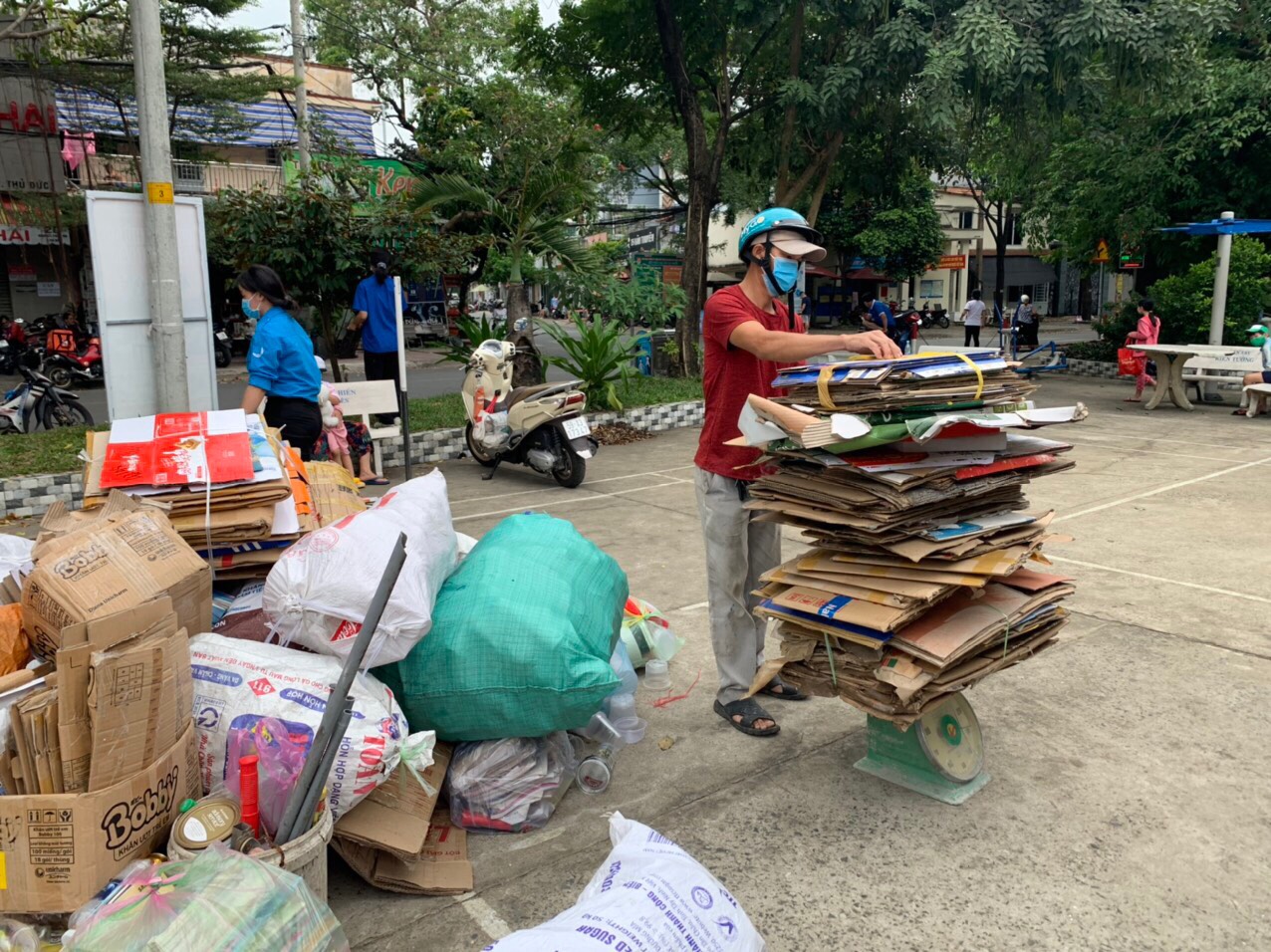 A man measures the weight of recyclable materials before exchanging them for rice in Binh Tho Ward, Thu Duc City, Ho Chi Minh City, December 11, 2021. Photo: Huu Chon / Tuoi Tre
