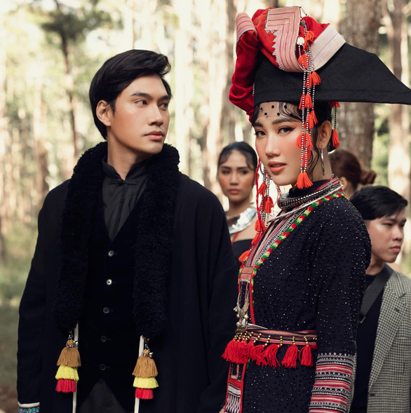 Designer Ly Qui Khanh stands next to a model wearing one of his new fashion designs in a photo that was posted on his Facebook account