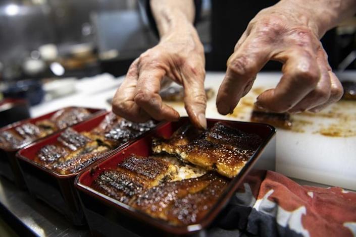 In this photo taken on April 16, 2021, Japanese chef Tsuyoshi Hachisuka prepares grilled eel before serving them to customers at his restaurant in Hamamatsu, Shizuoka prefecture. Photo: AFP